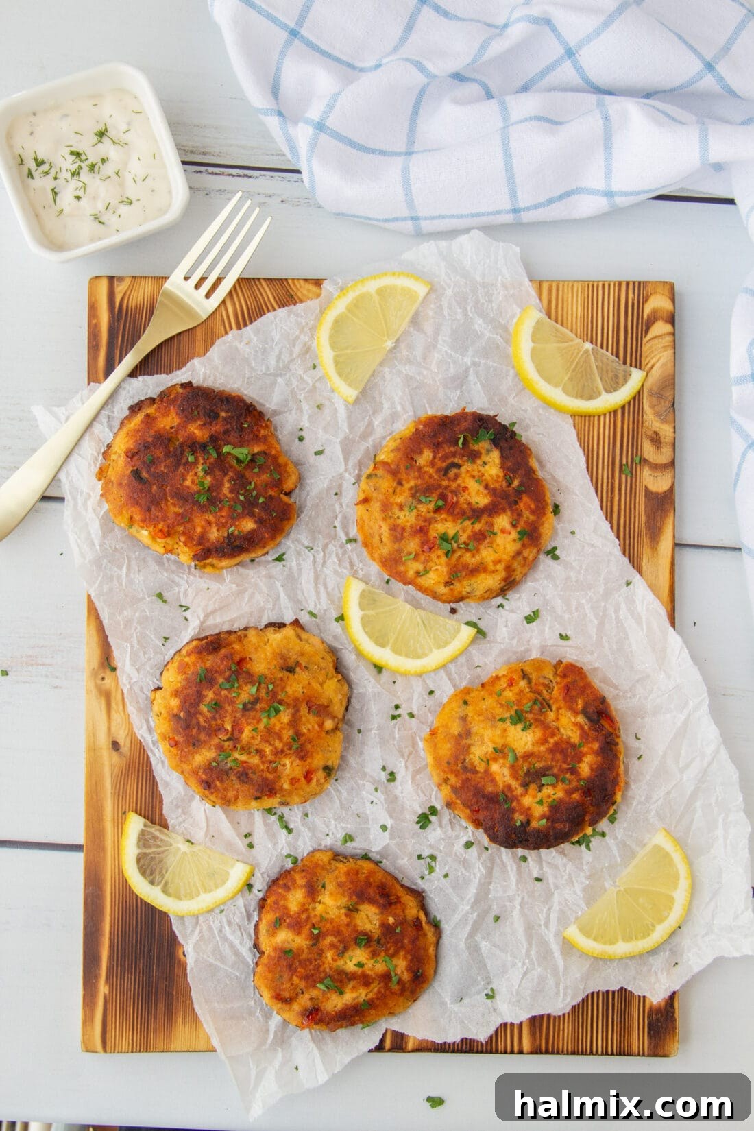 Crispy golden-brown smoked salmon fish cakes on a cutting board, garnished with fresh herbs, ready to be served.
