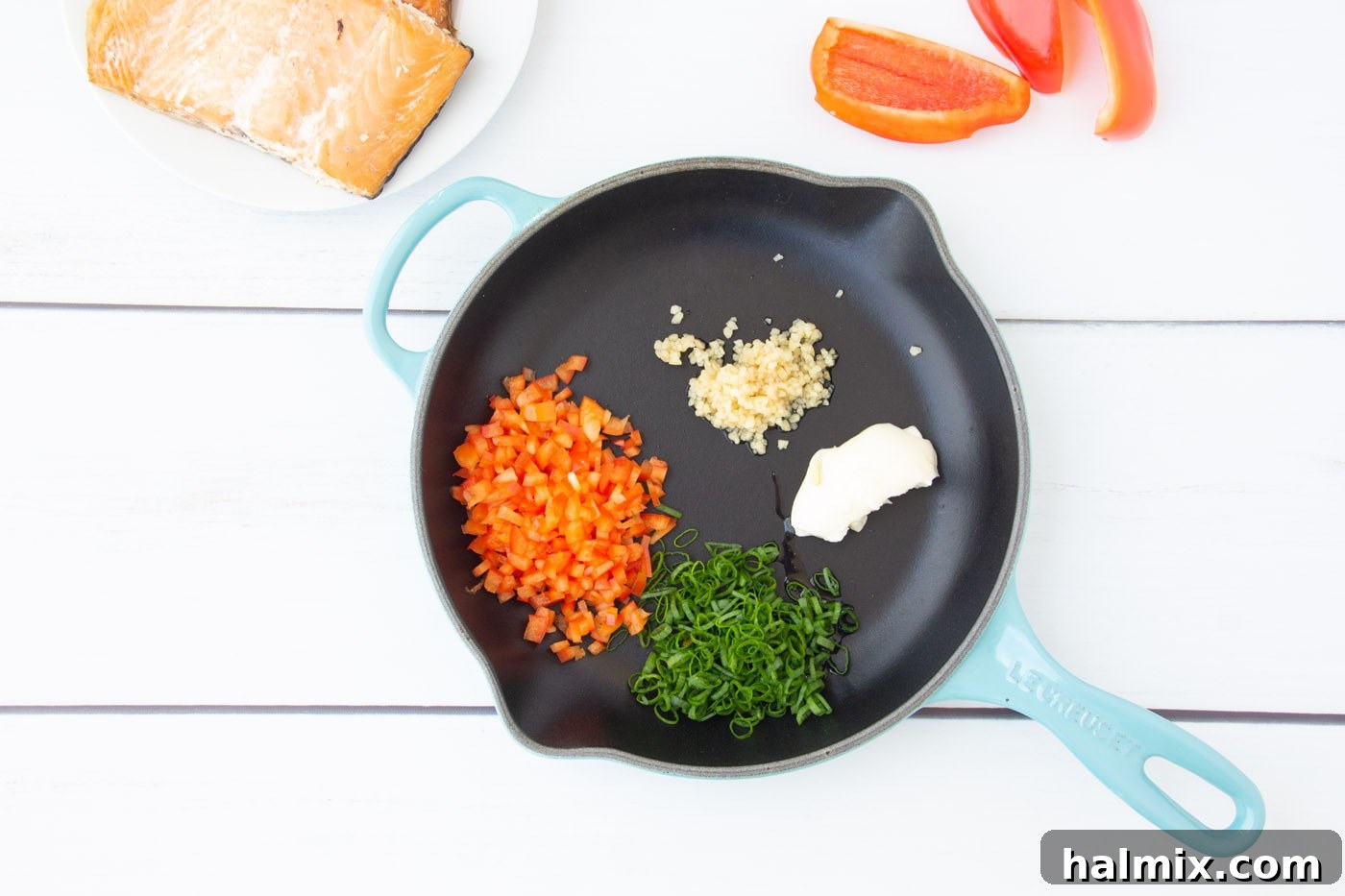 Sautéing red bell pepper, green onion, and garlic in butter in a skillet
