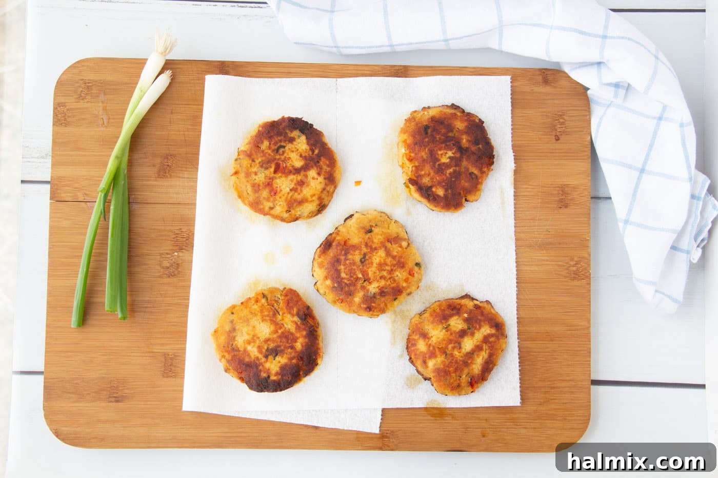 Cooked fish cakes resting on a paper towel-lined plate