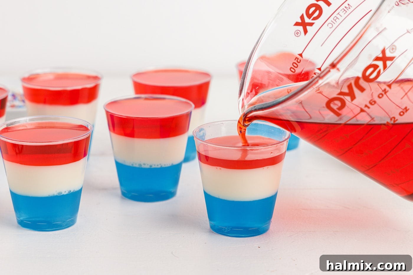 pouring red jello on top of blue and white