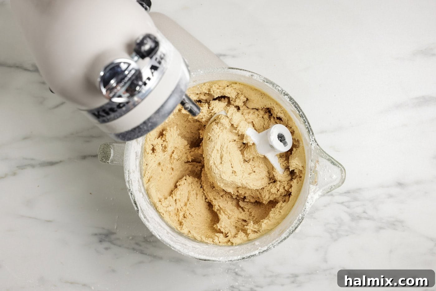 Cookie dough in a stand mixer bowl with the paddle attachment, ready for chocolate