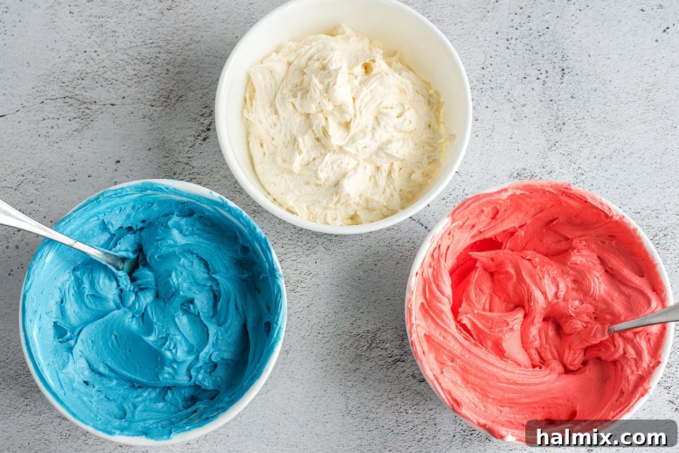 Stars and Stripes Cone Cakes 11 Three bowls of buttercream frosting in red, white, and blue colors