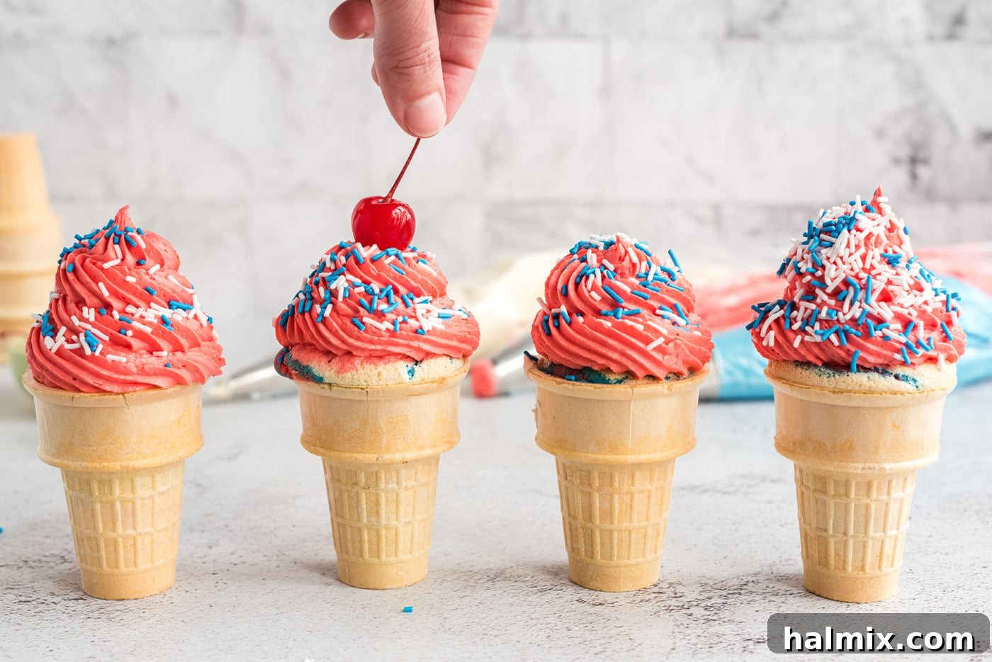 Stars and Stripes Cone Cakes 13 Adding a maraschino cherry to a patriotic ice cream cone cupcake