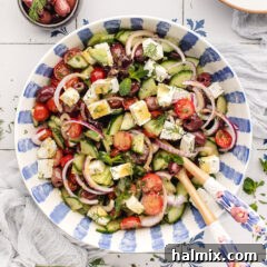 Bowl of Greek Salad with serving spoons in it