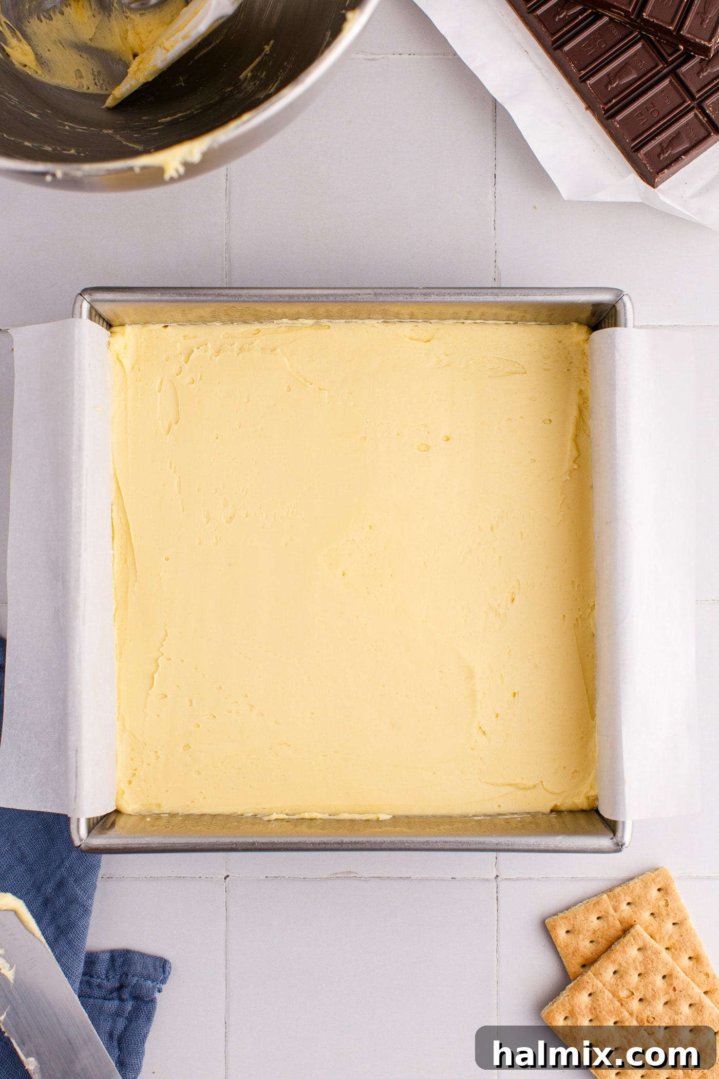 Nanaimo bar custard filling spread over the crust layer.