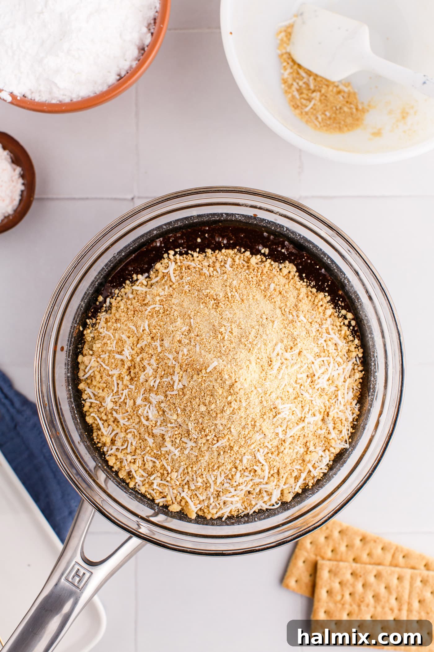 Crumb and coconut mixture being added to the chocolate base.