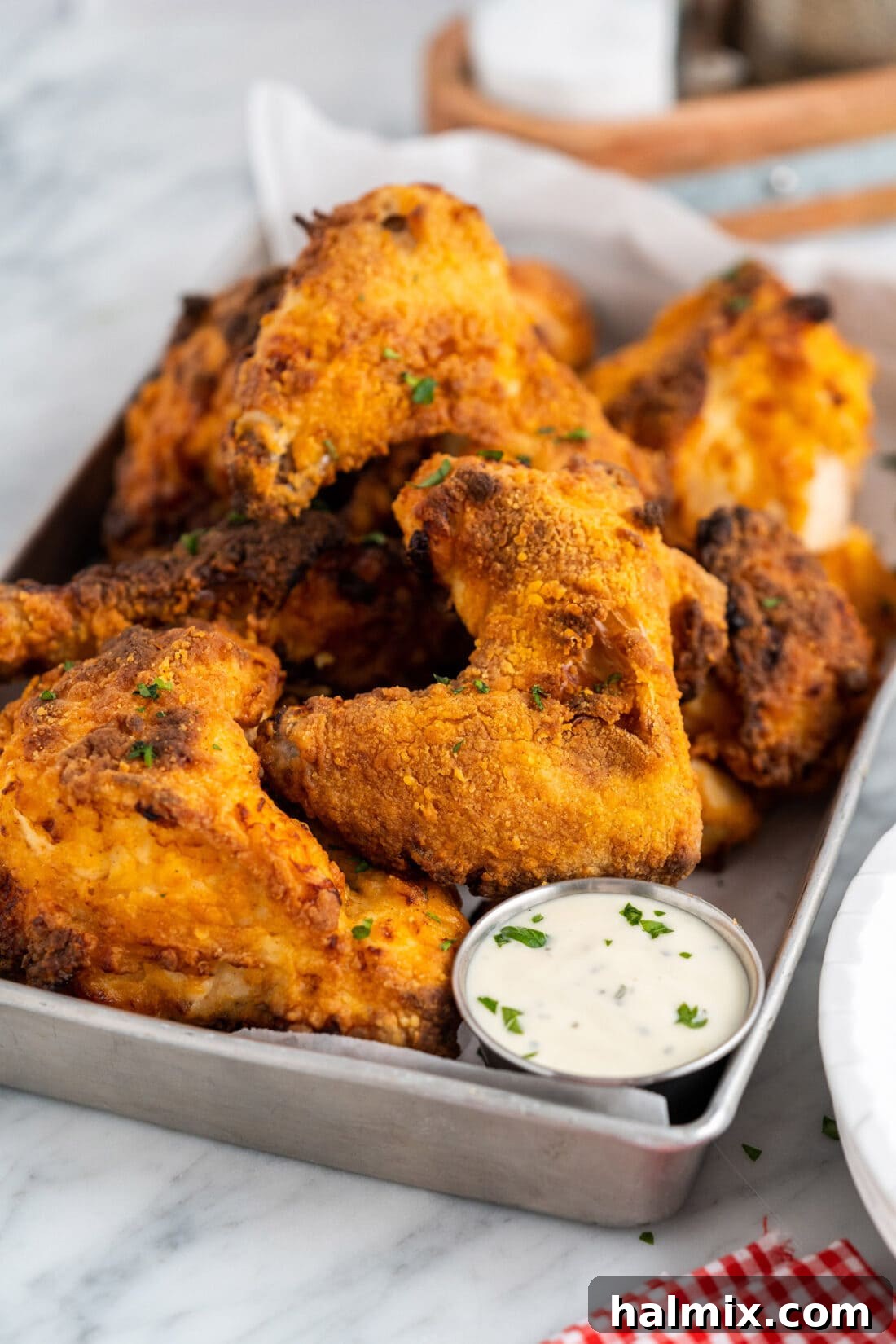A large serving tray filled with freshly cooked Air Fryer Fried Chicken pieces, presented beautifully with a side of dipping sauce, ready for a family meal.