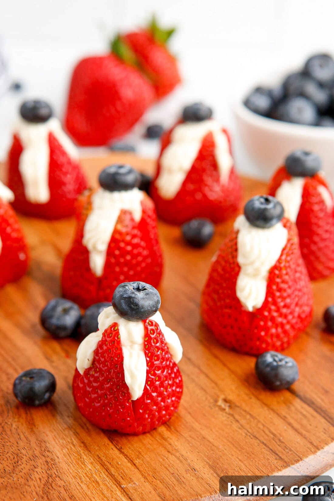 Red, white, and blue Cheesecake Stuffed Strawberries, garnished with blueberries, ideal for patriotic celebrations.
