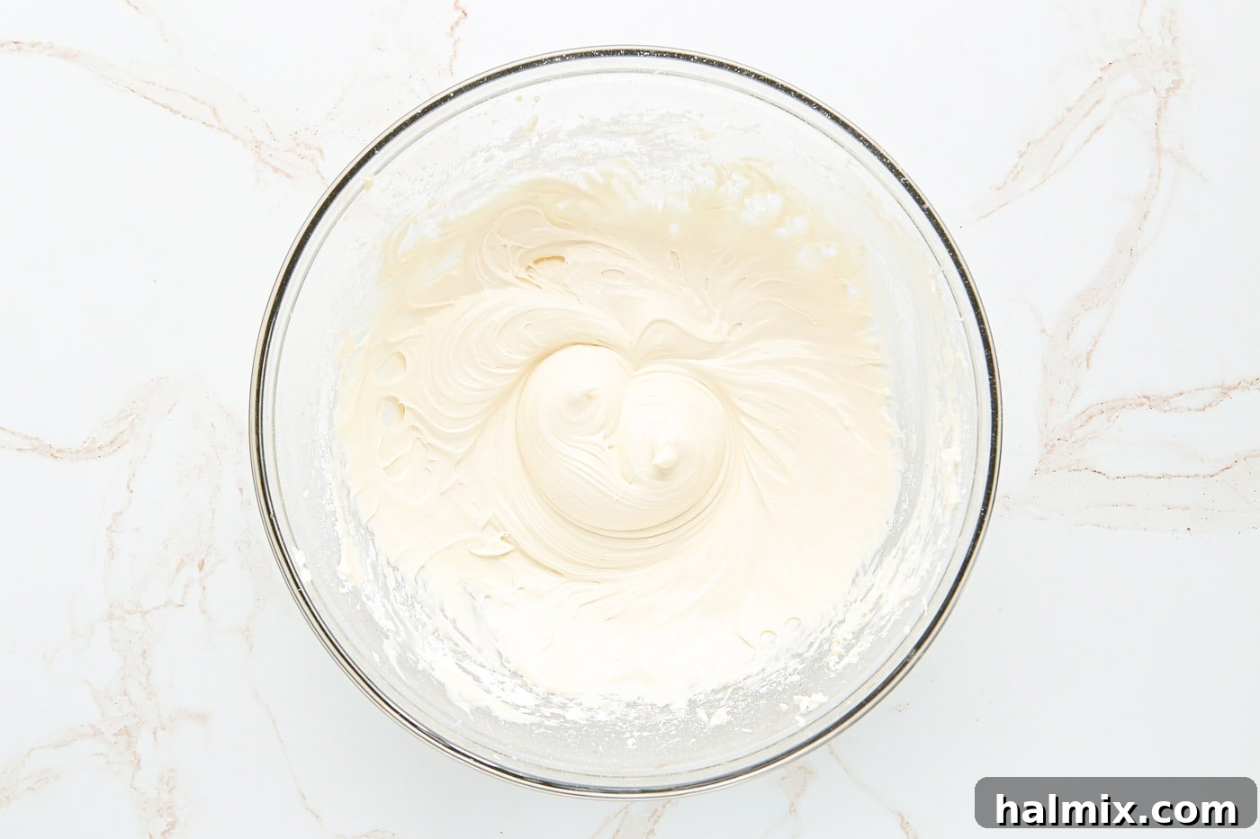 Beating cream cheese until smooth and creamy in a mixing bowl.