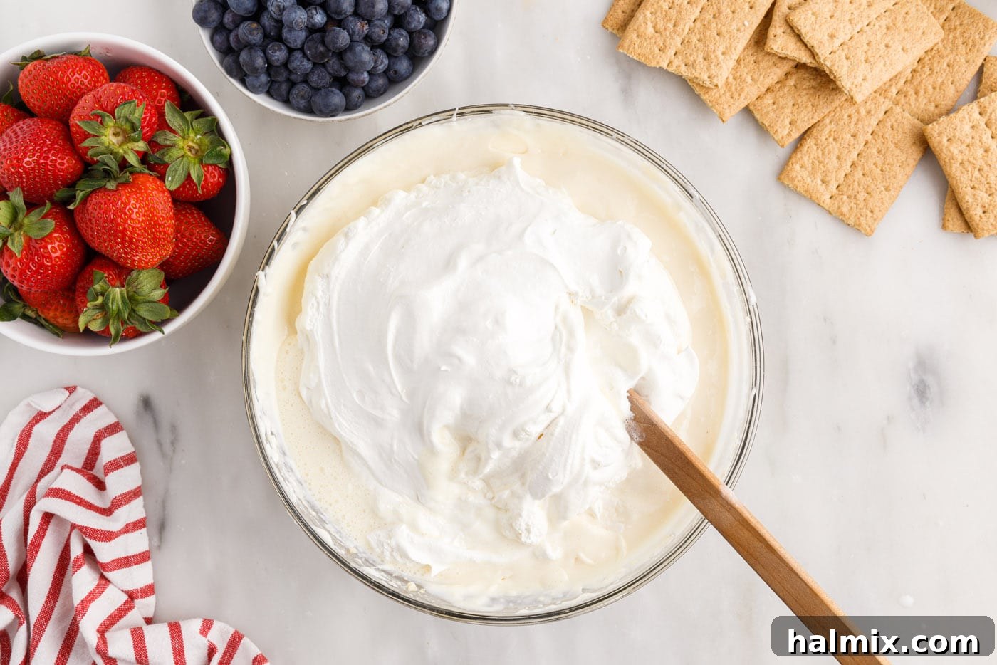 Folding Cool Whip into the cream cheese pudding mixture with a spatula.