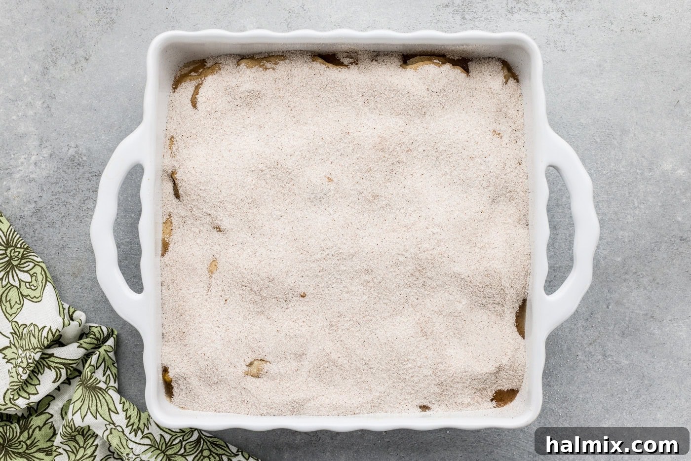 overhead photo of sugar mixture on top of cobbler batter in a dish