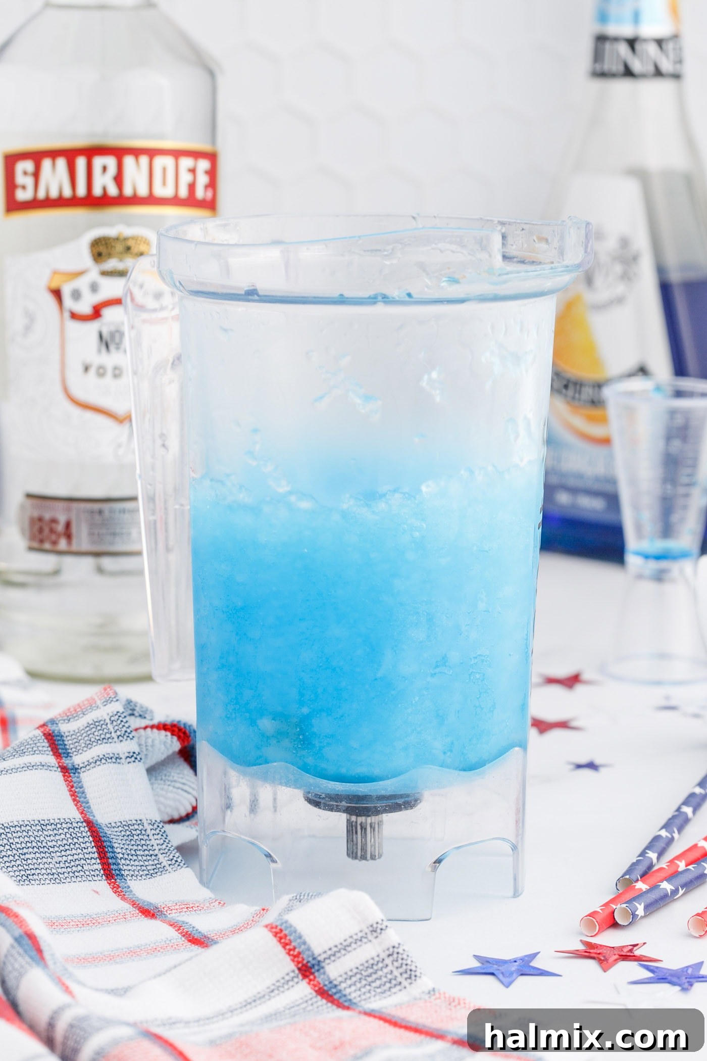 Blue curacao lemonade slush in a blender, preparing the final blue layer of the cocktail.