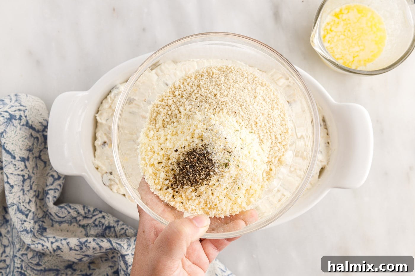 Panko breadcrumbs, Parmesan cheese, and seasonings being mixed in a small bowl