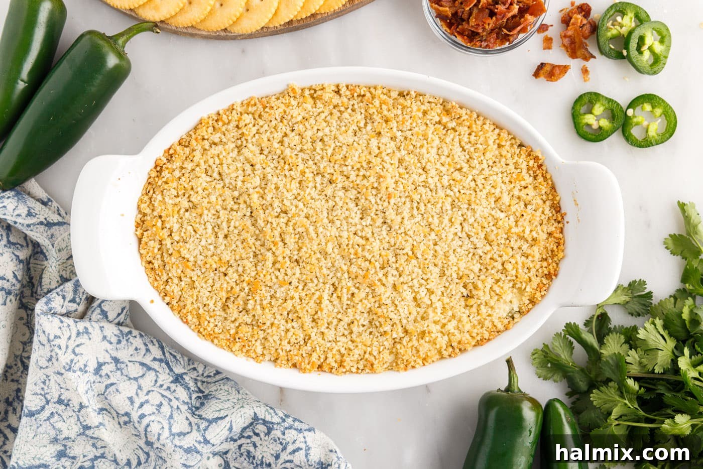 Freshly baked jalapeno popper dip in a dish, showing a golden-brown, bubbly top