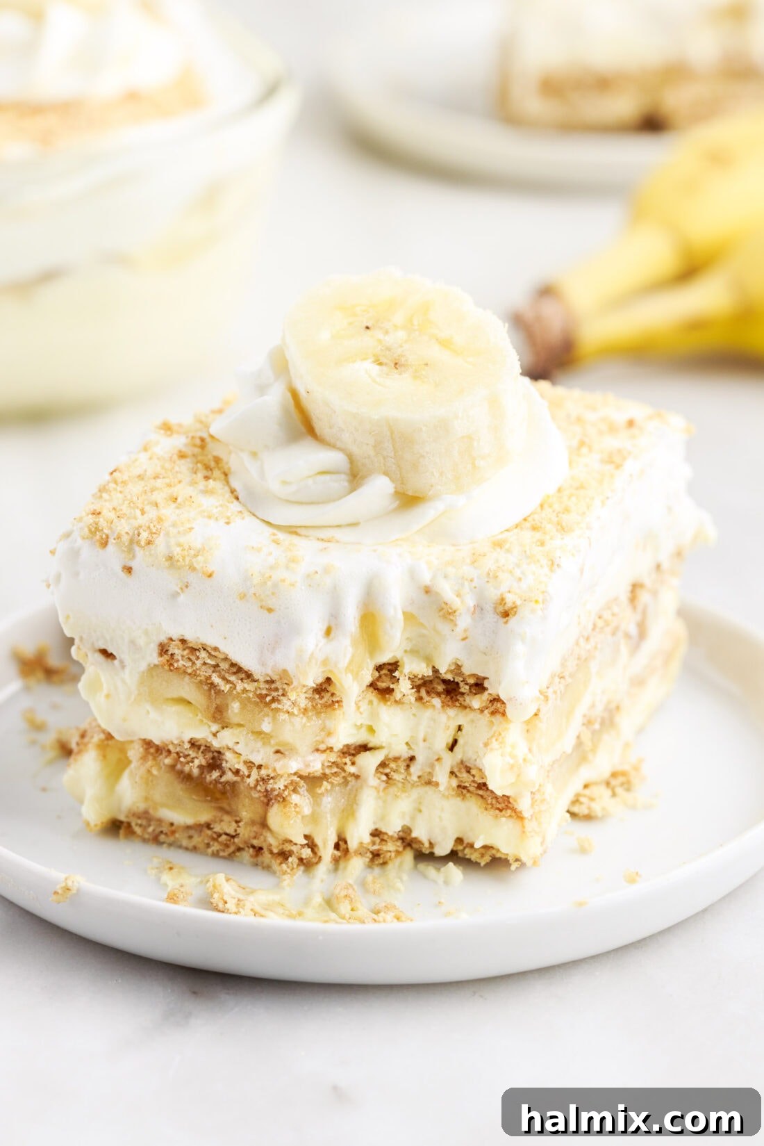 A slice of Banana Cream Pie Icebox Cake with a fork taking a bite, showcasing the layers.