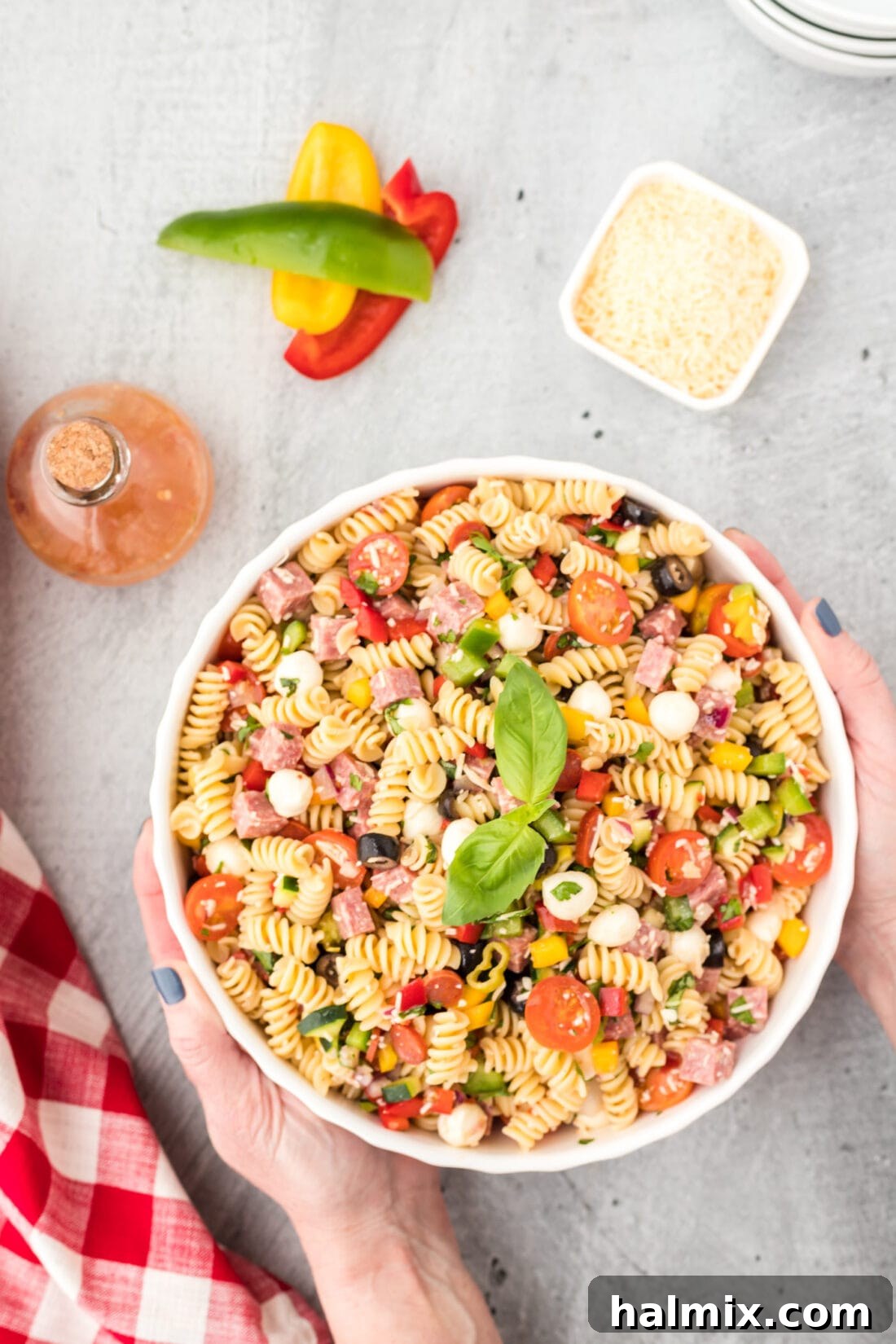 Trattoria Toss 3 hands picking up a bowl Italian Pasta Salad