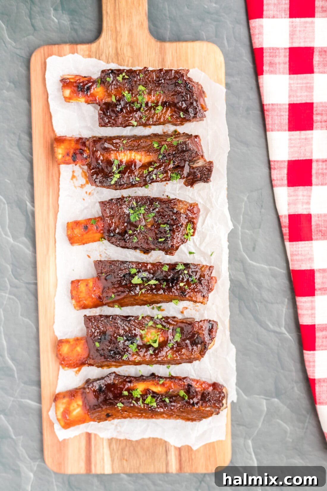 Instant Pot Beef Ribs on a long cutting board, perfectly cooked and ready to serve