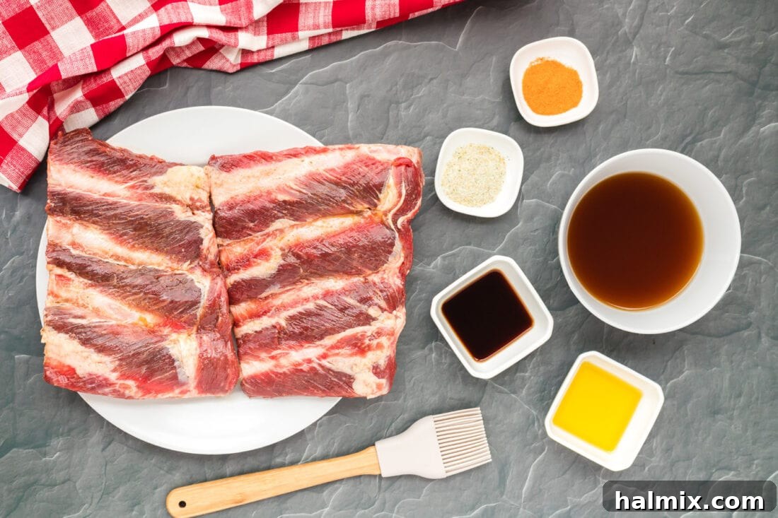 A selection of ingredients for Instant Pot Beef Ribs including beef riblets, spices, broth, and liquid smoke