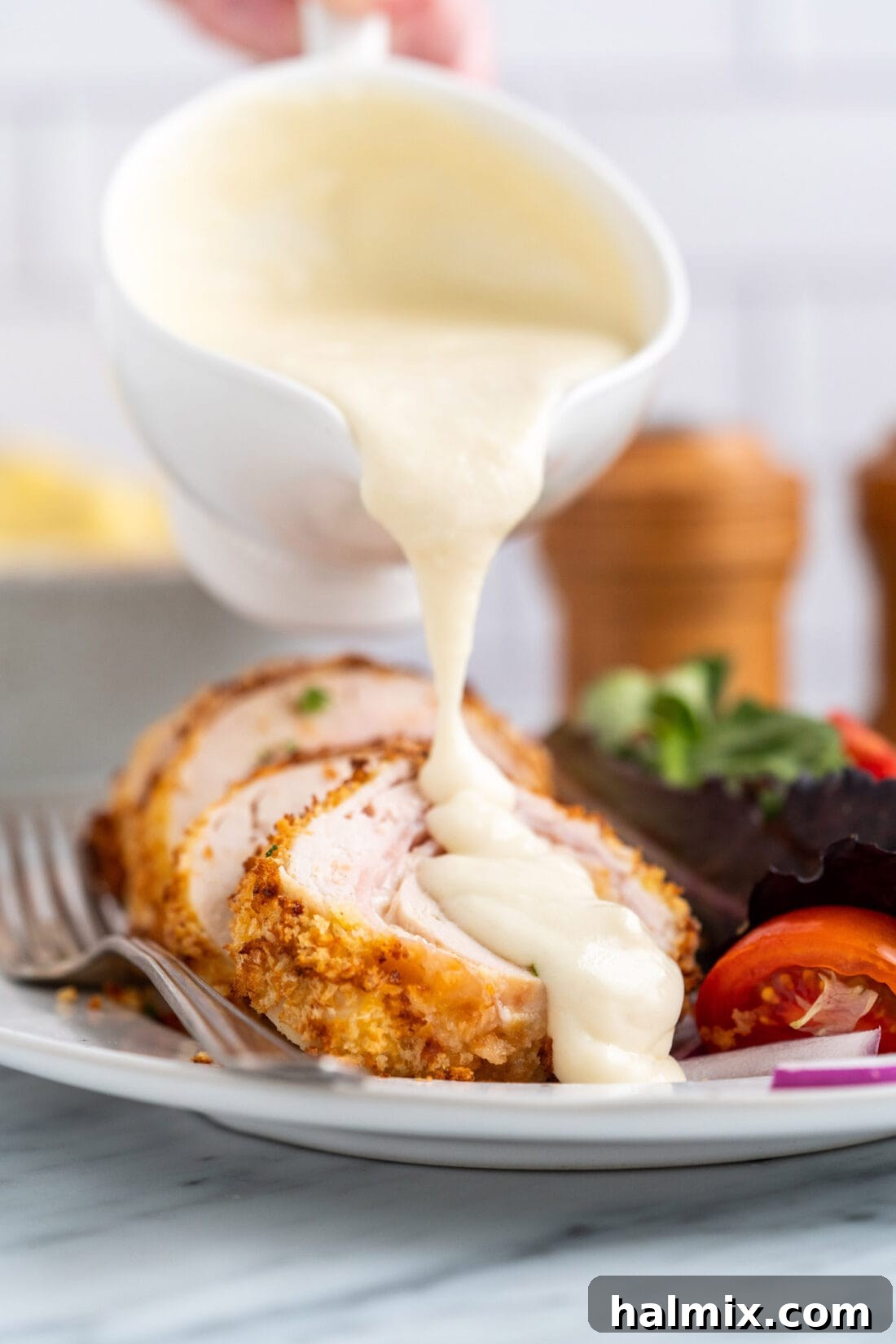Crispy Air Fryer Chicken Cordon Bleu 2 Drizzling creamy Dijon sauce over golden Air Fryer Chicken Cordon Bleu, highlighting its irresistible appeal.