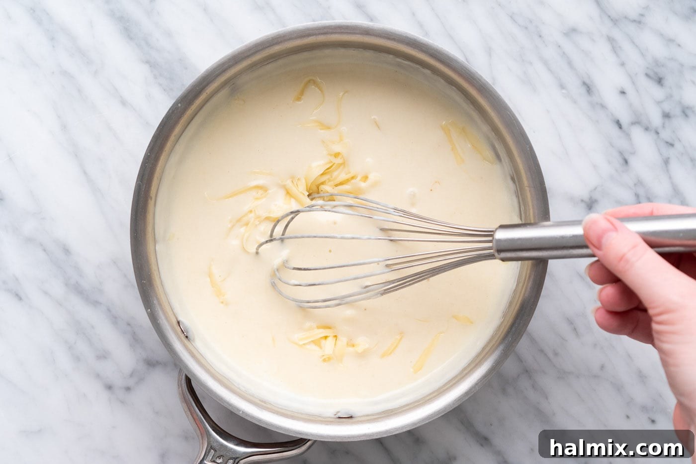 Crispy Air Fryer Chicken Cordon Bleu 15 Whisking Dijon cream sauce ingredients in a saucepan to create a smooth, thick sauce.