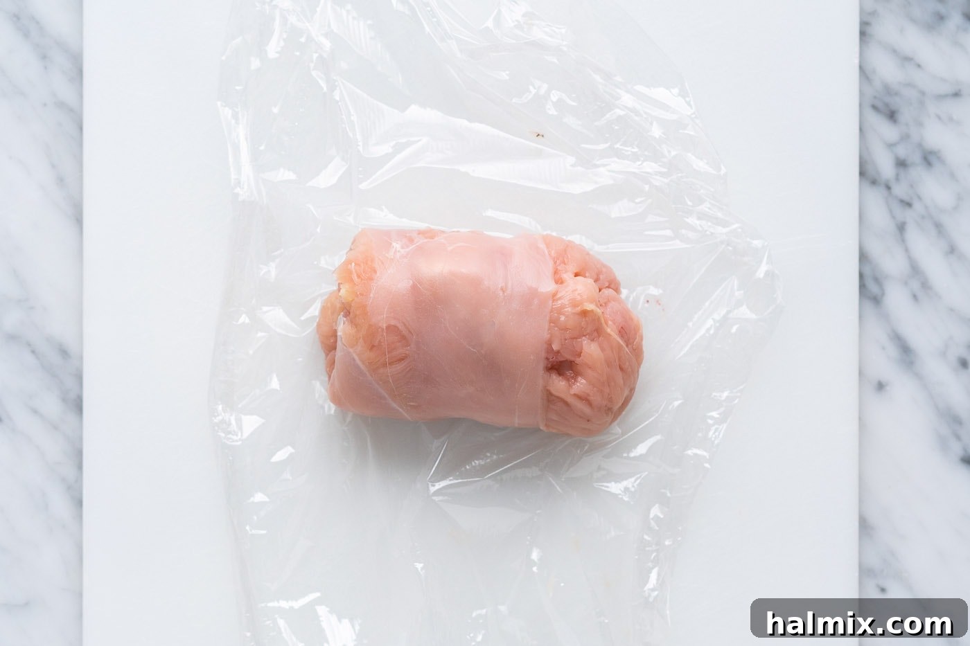 Crispy Air Fryer Chicken Cordon Bleu 8 Carefully rolling the chicken cordon bleu with the aid of plastic wrap to keep the filling secure.