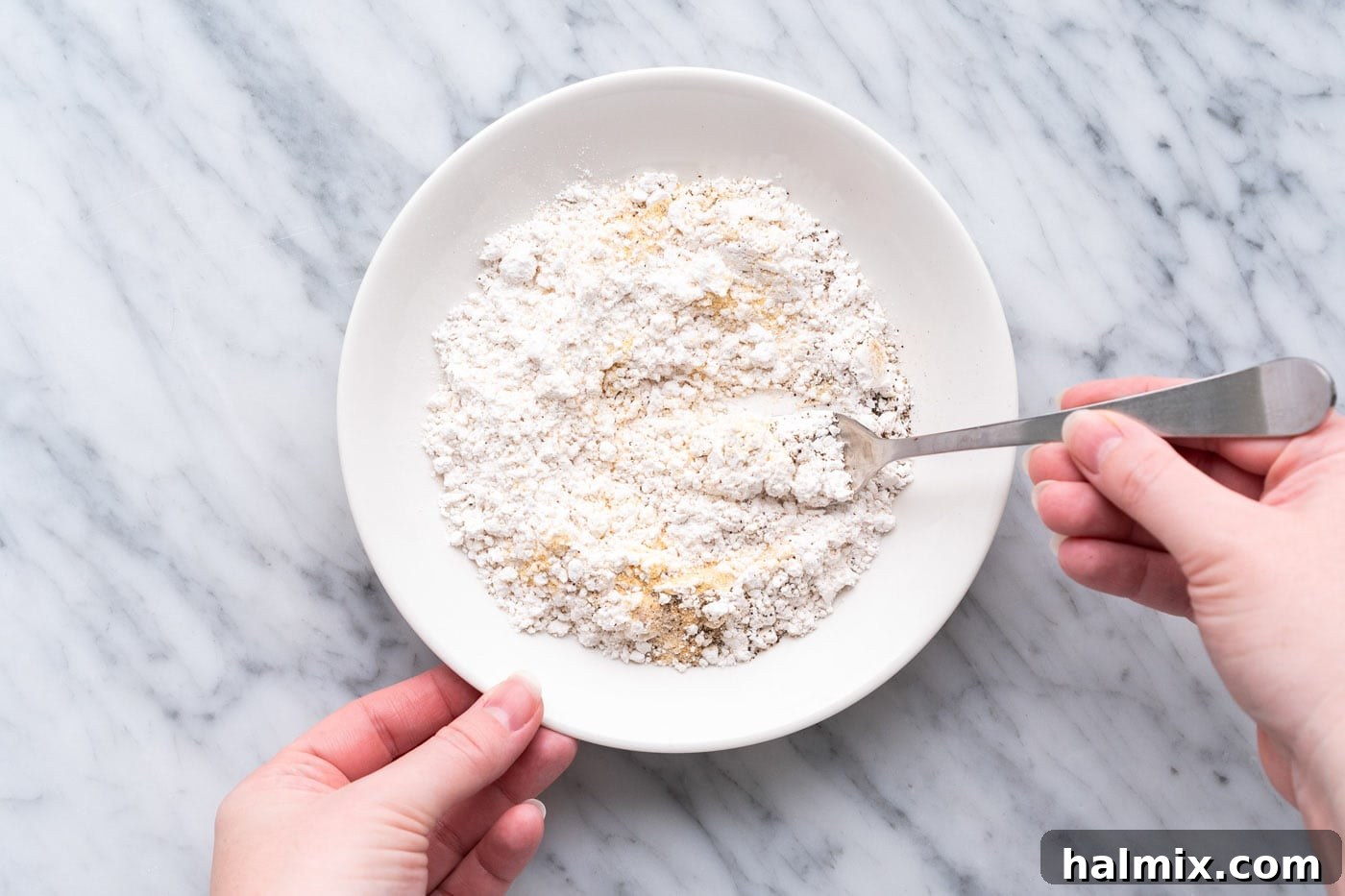 Crispy Air Fryer Chicken Cordon Bleu 9 A bowl containing a mix of flour and seasonings for the dredging process.
