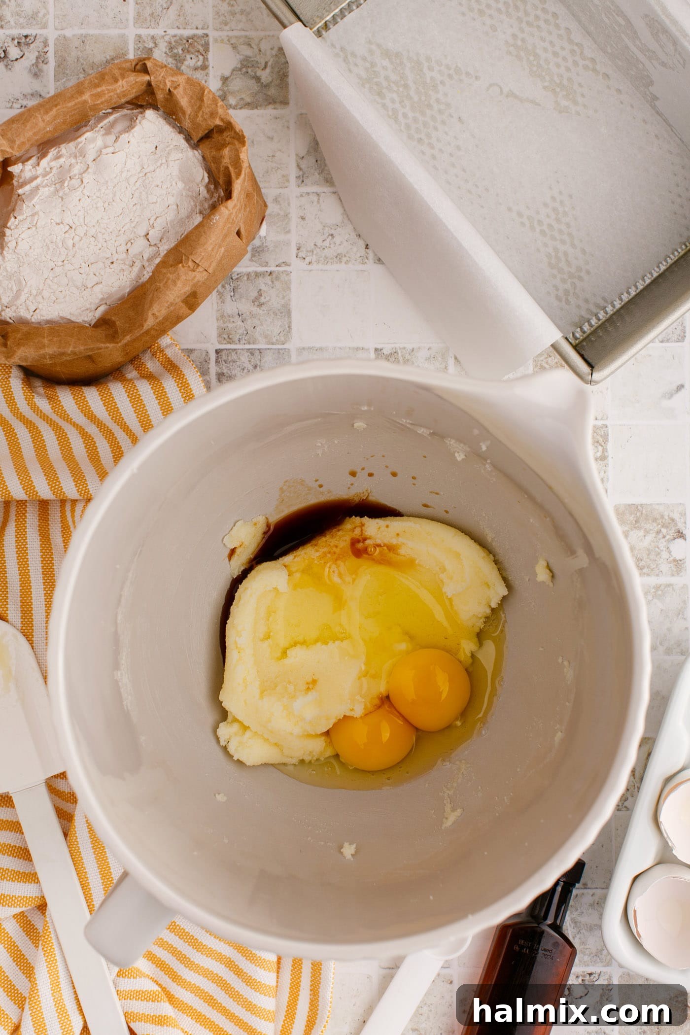 Adding eggs and vanilla extract to the creamed butter and sugar mixture