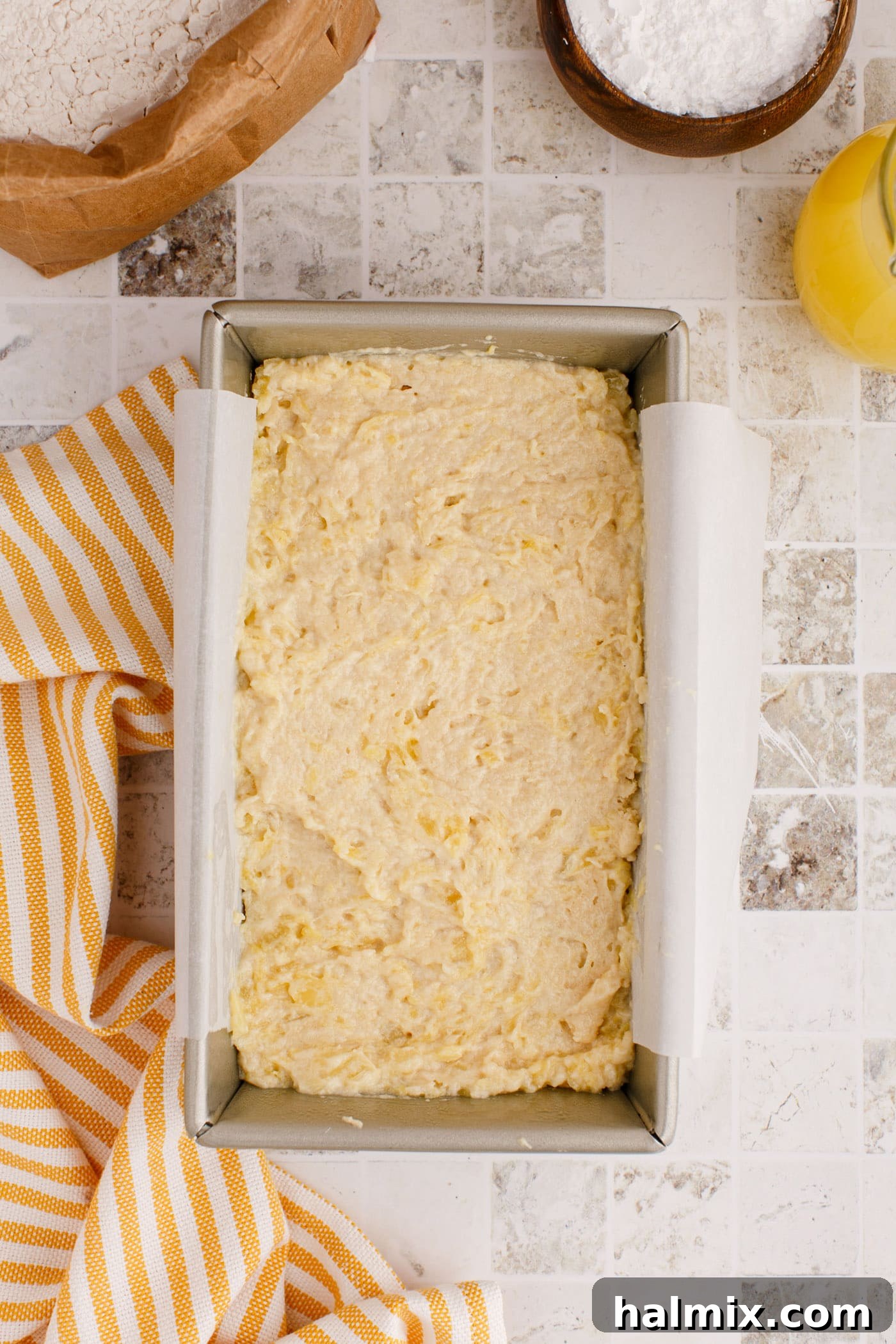 Pineapple quick bread batter poured into a greased loaf pan