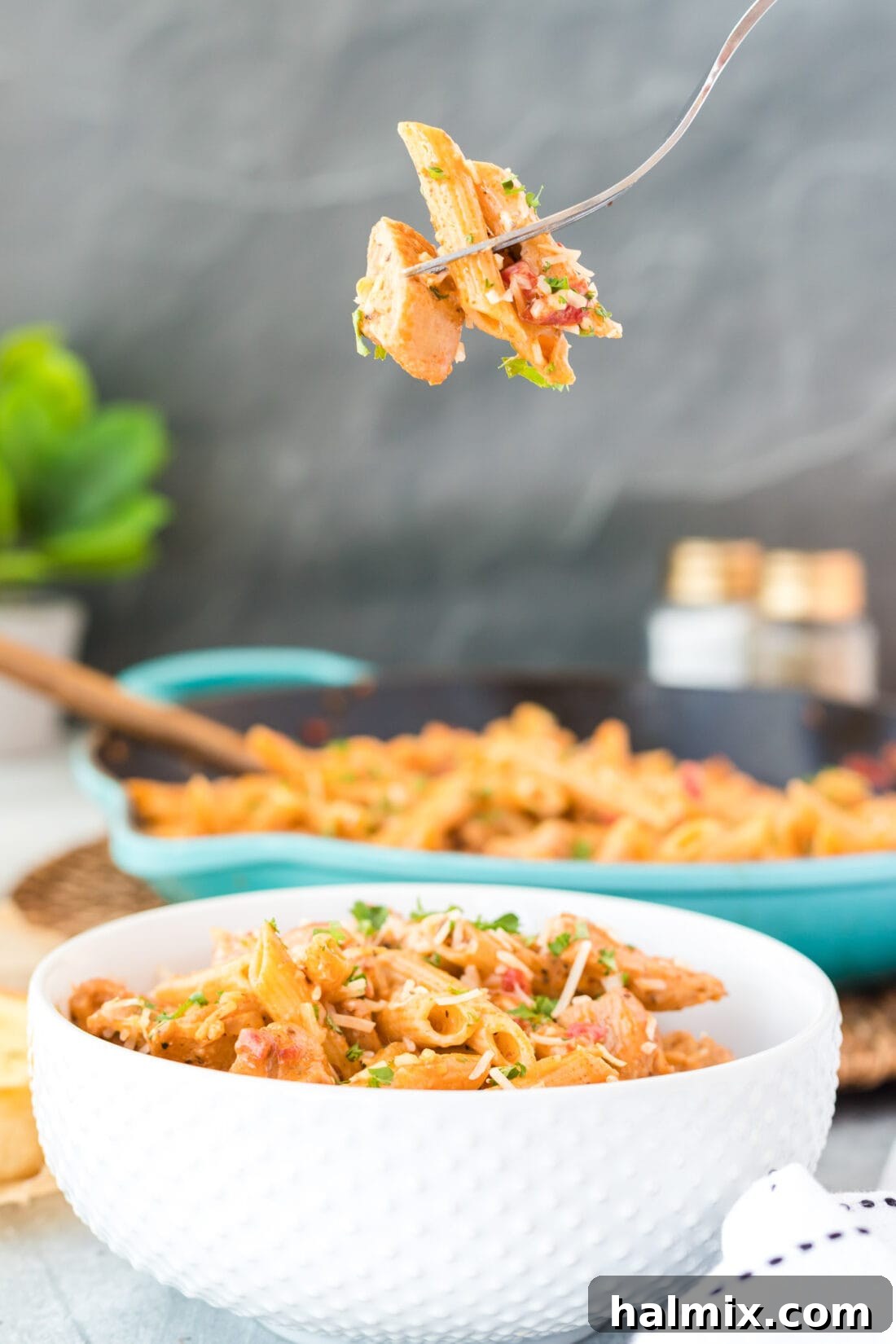 A fork lifting a generous portion of creamy Cajun Chicken Pasta from a bowl, highlighting the rich texture and flavors.