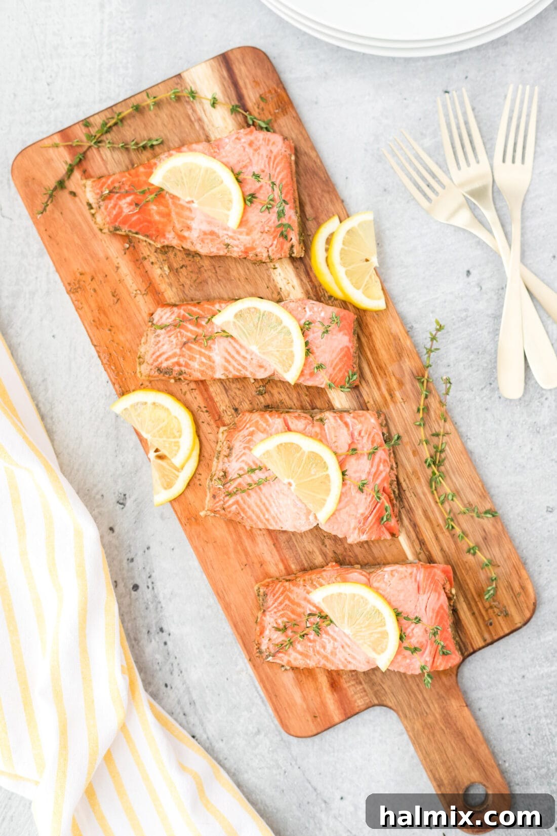 Silently, I'm identifying the core request: translate and "originalize" a Turkish title into English, ensuring only one plain English title is output, with no special characters or introductory phrases. The input is "Poached Salmon". This is already English. Therefore, the task is to "originalize" Poached Salmon into something similar but perhaps more evocative or descriptive, while still being plain English. 1. **Analyze "Poached Salmon"**: It's a straightforward description of a dish.
2. **Brainstorm variations/enhancements**: * Focus on the *method*: Gently Poached Salmon, Perfectly Poached Salmon. * Focus on the *result/experience*: Delicate Poached Salmon, Succulent Poached Salmon. * Focus on *simplicity/elegance*: Simple Poached Salmon, Elegant Poached Salmon. * Add a *pairing/context* (if it were a recipe, but here it's just a title): Poached Salmon with Dill, Lemon Poached Salmon. (Too specific if the original wasn't.)
3. **Select the best "originalization"**: I need one that sounds a little more appealing or descriptive than just "Poached Salmon" without drastically changing its meaning or adding ingredients that aren't implied. "Delicate Poached Salmon" or "Succulent Poached Salmon" both work well to enhance the basic description. "Perfectly Poached Salmon" is also good. Let's go with "Delicate Poached Salmon" as it evokes both the texture and the careful cooking method. 2 Perfectly Poached Salmon fillets on a wooden cutting board, garnished with fresh dill and lemon slices.