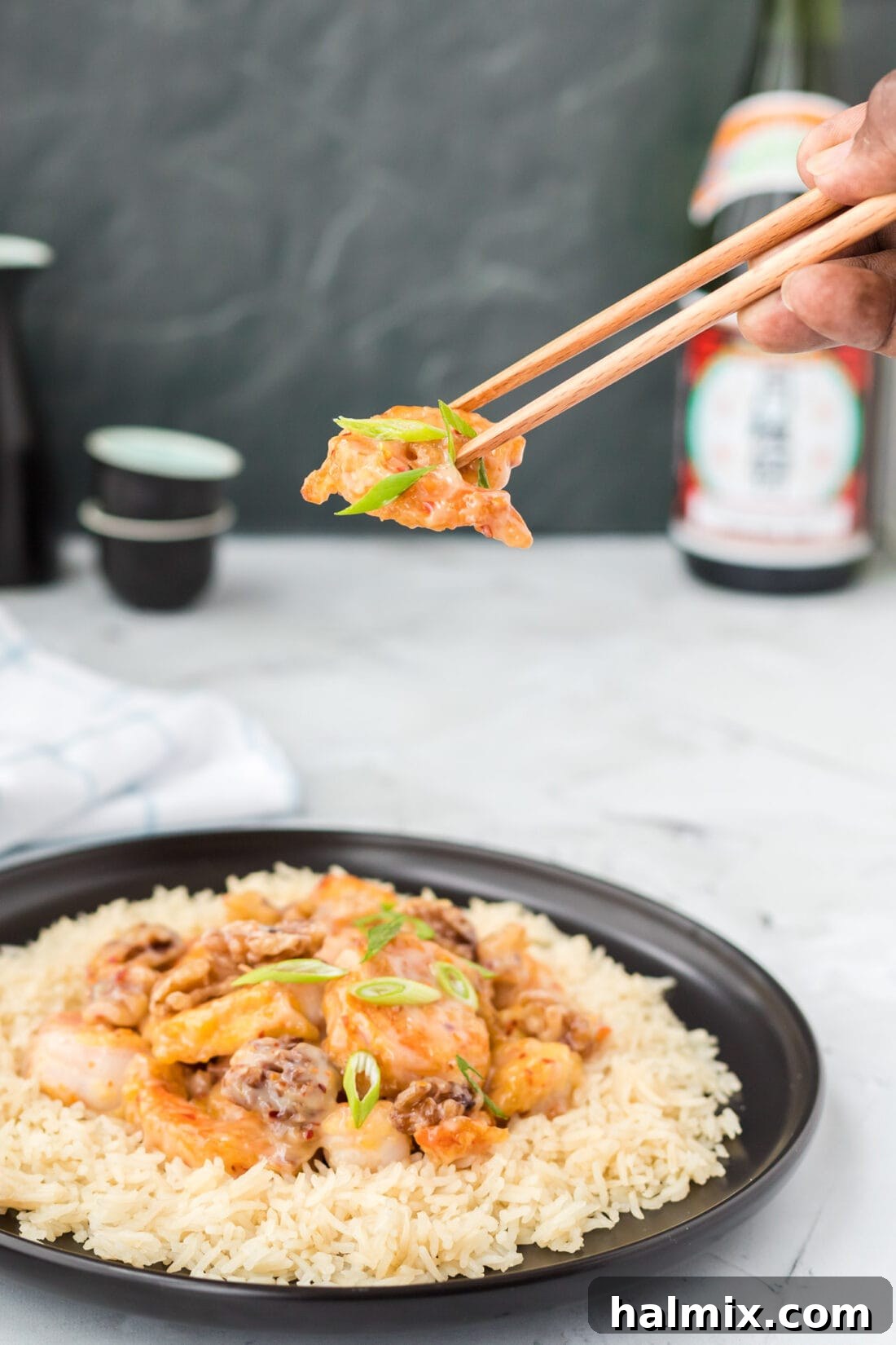 Golden Glazed Honey Walnut Shrimp 2 Crispy Honey Walnut Shrimp being lifted with chopsticks, highlighting its golden texture and rich sauce