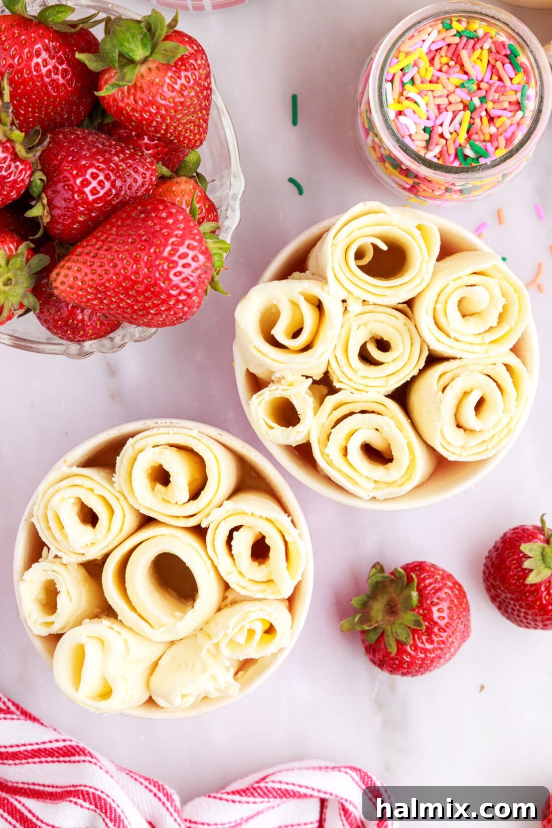 Collection of rolled ice cream servings in various small containers, highlighting customization options.