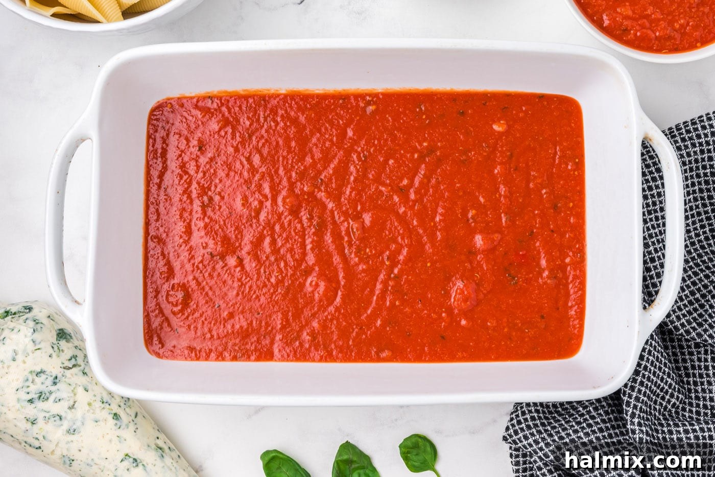 layer of marinara sauce on bottom of a baking dish