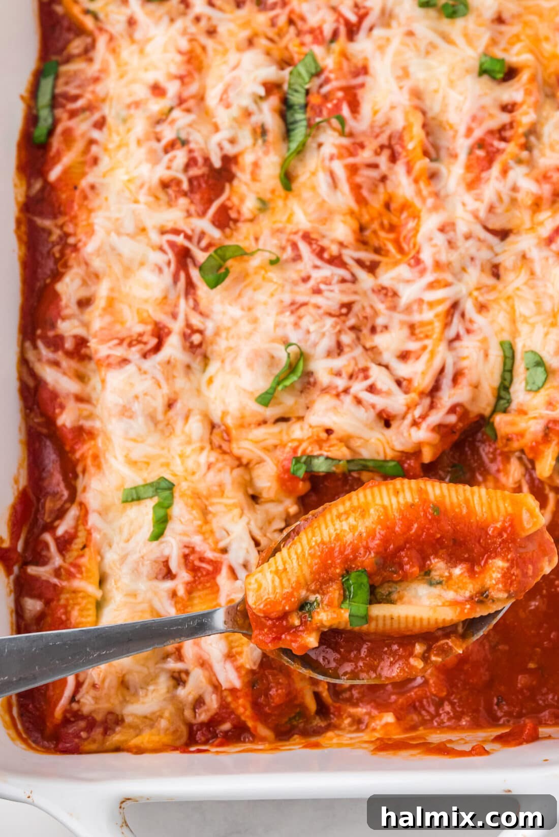 spoon in a pan of Stuffed Shells