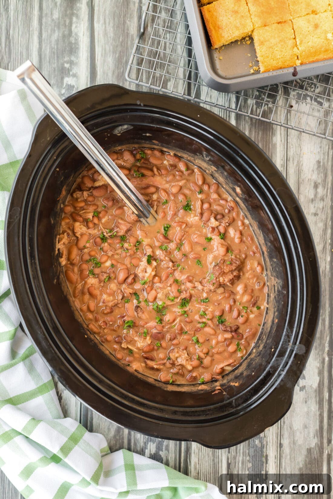 Flavorful Slow Cooker Pinto Beans with a ladle, ready to serve