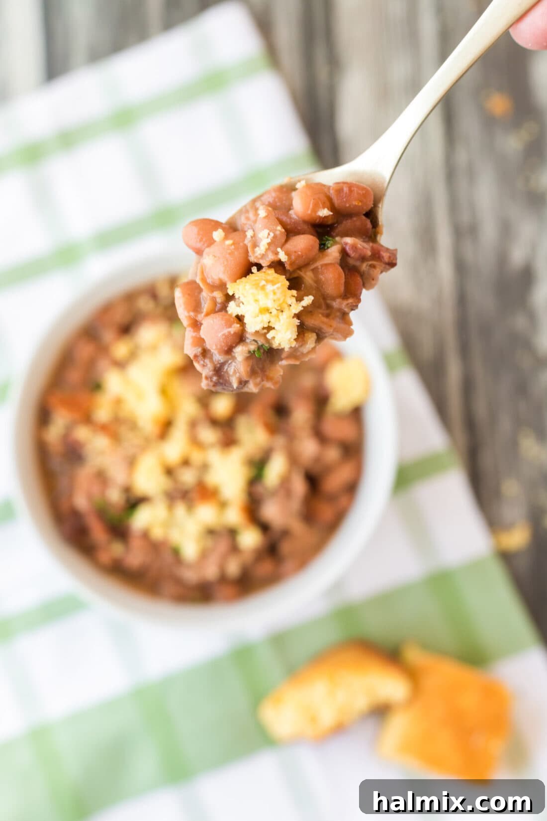 Spoonful of Slow Cooker Pinto Beans served with a piece of cornbread