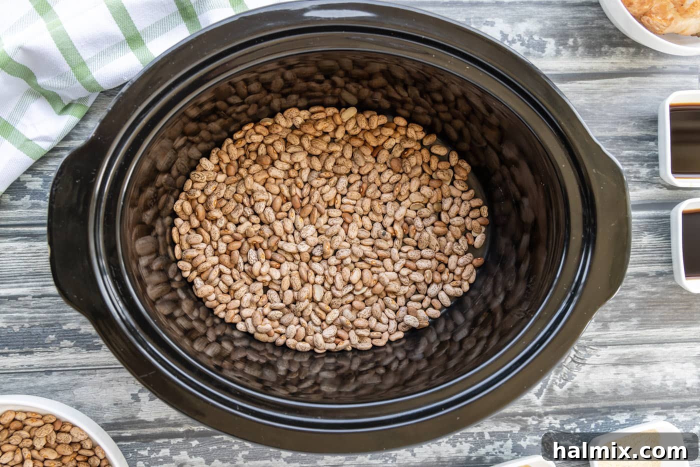 Dried pinto beans forming the first layer in a crockpot