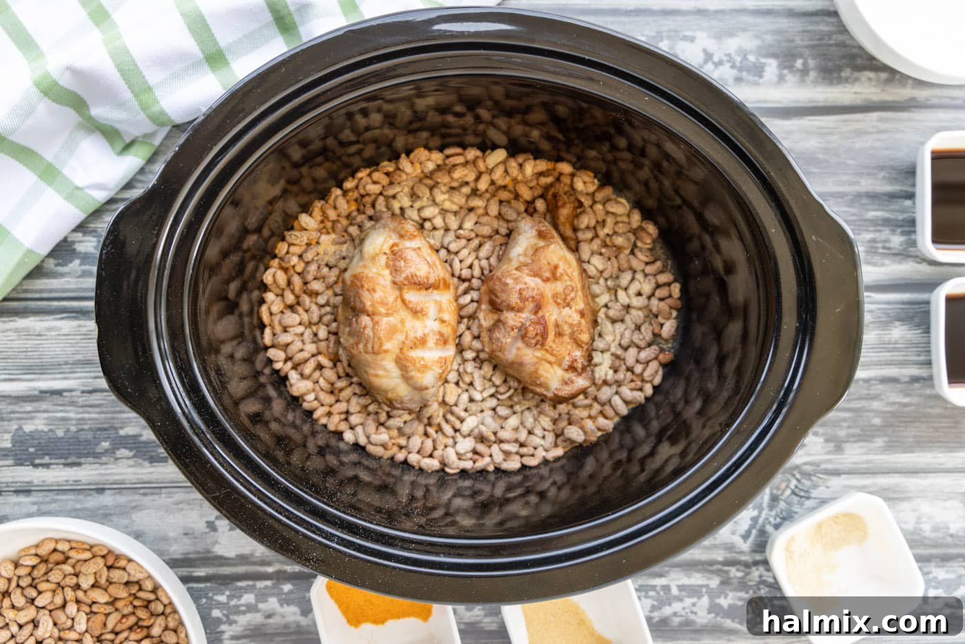 Smoked turkey tails placed on top of seasoned pinto beans in a crockpot