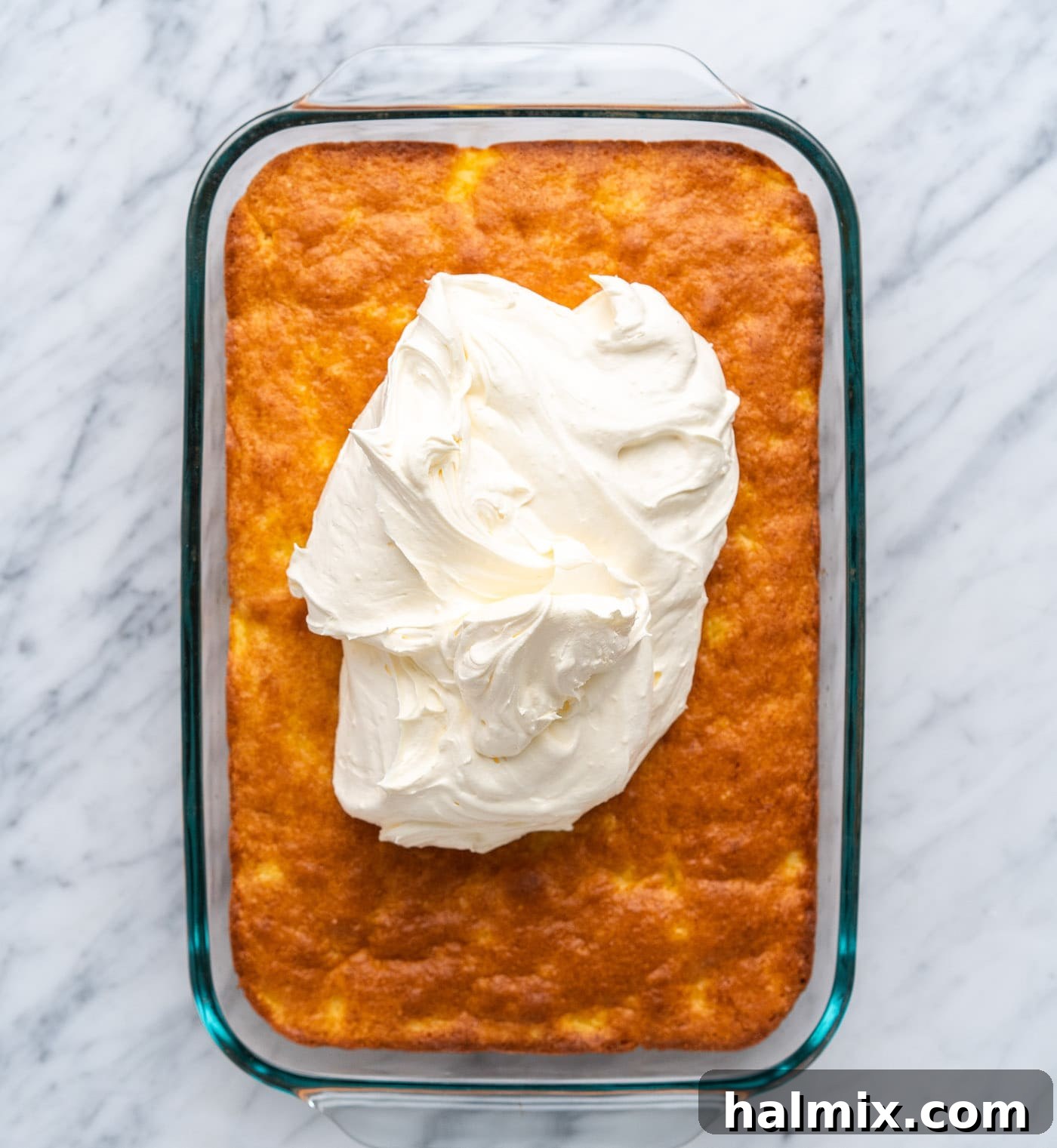 Sun-Kissed Pineapple Dream 12 pineapple frosting being spread on a cooled cake, creating a smooth layer