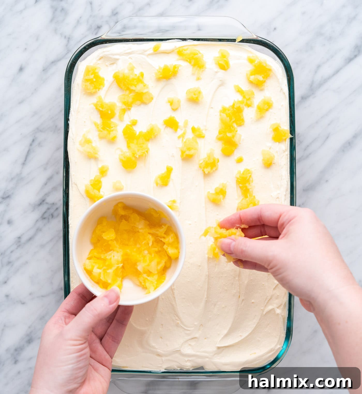 Sun-Kissed Pineapple Dream 13 sprinkling crushed pineapple on top of a frosted cake for garnish