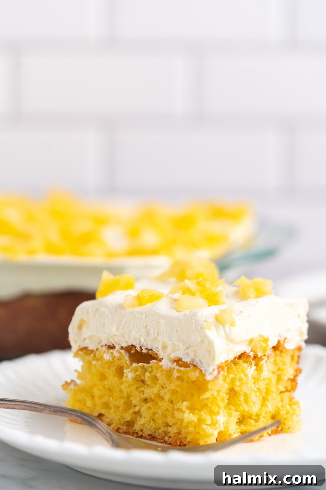 Sun-Kissed Pineapple Dream 14 a delightful slice of Pineapple Sunshine Cake presented on a clean white plate