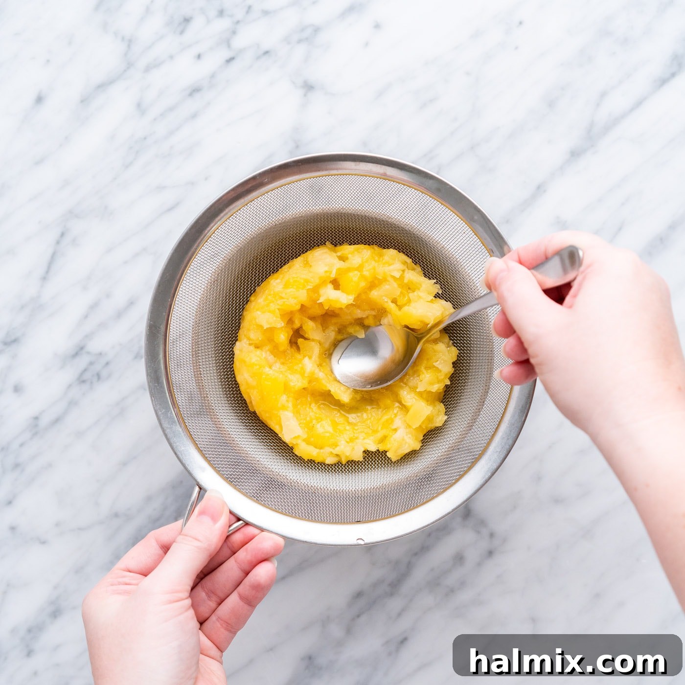 Sun-Kissed Pineapple Dream 9 straining crushed pineapple, separating the juice from the fruit