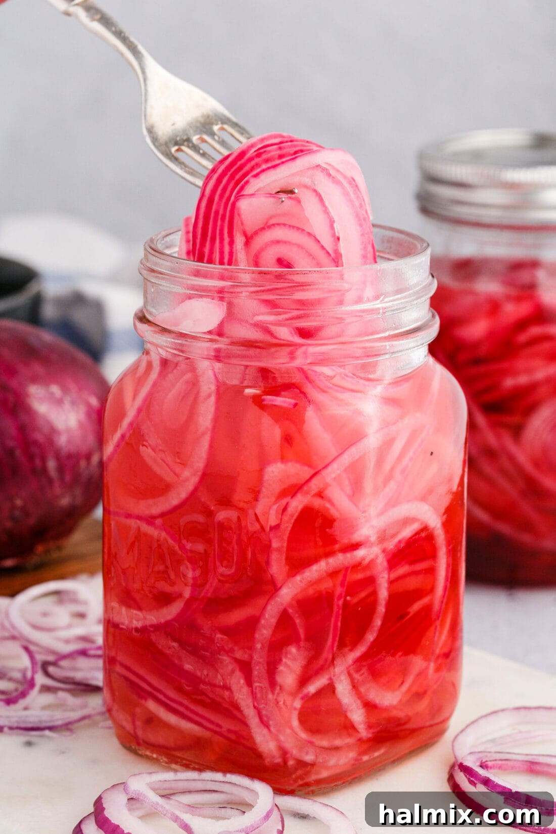 lifting Pickled Onions with a fork from a jar