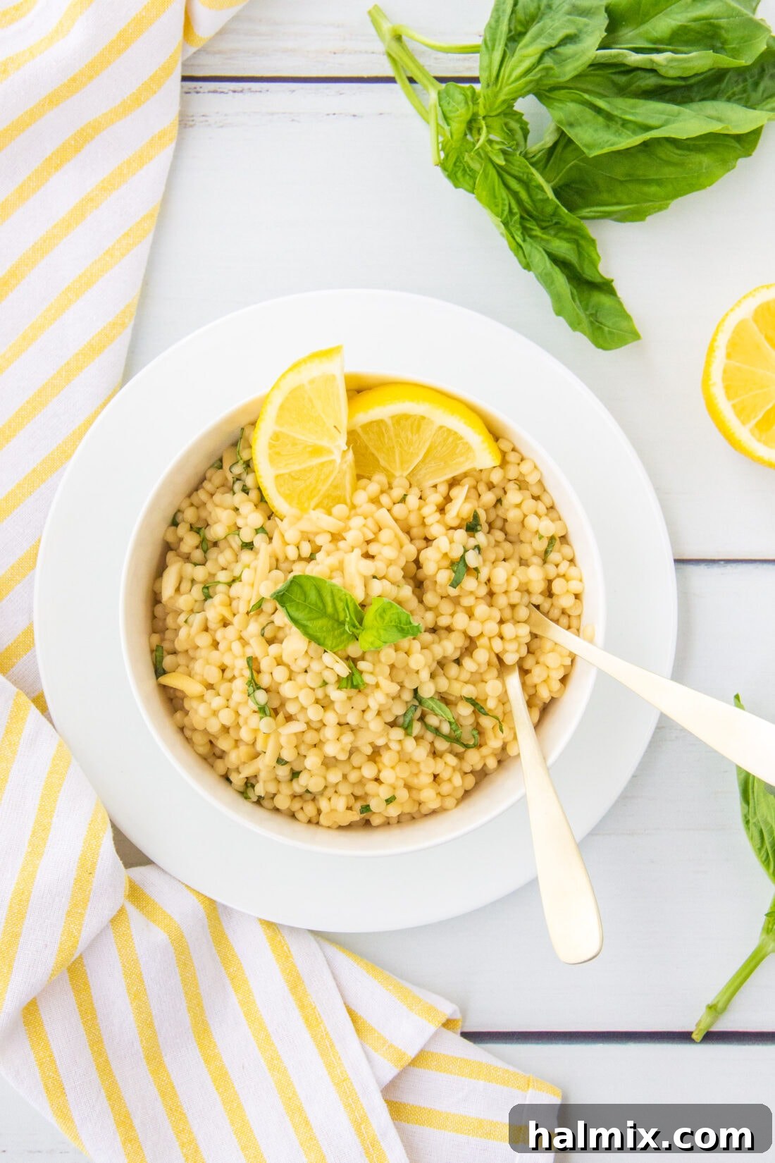 Zesty Lemon Couscous 2 Lemon Couscous in a white bowl, garnished with fresh basil leaves, ready to be served.