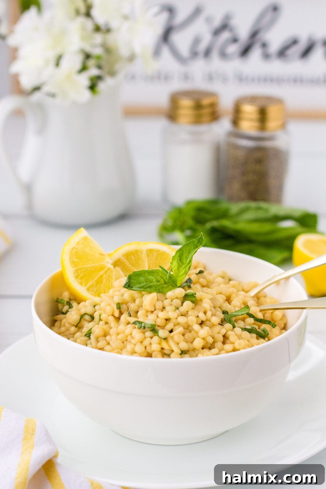 Zesty Lemon Couscous 3 Lemon Couscous in a white bowl, with salt and pepper shakers in the blurred background, emphasizing its ready-to-serve appeal.