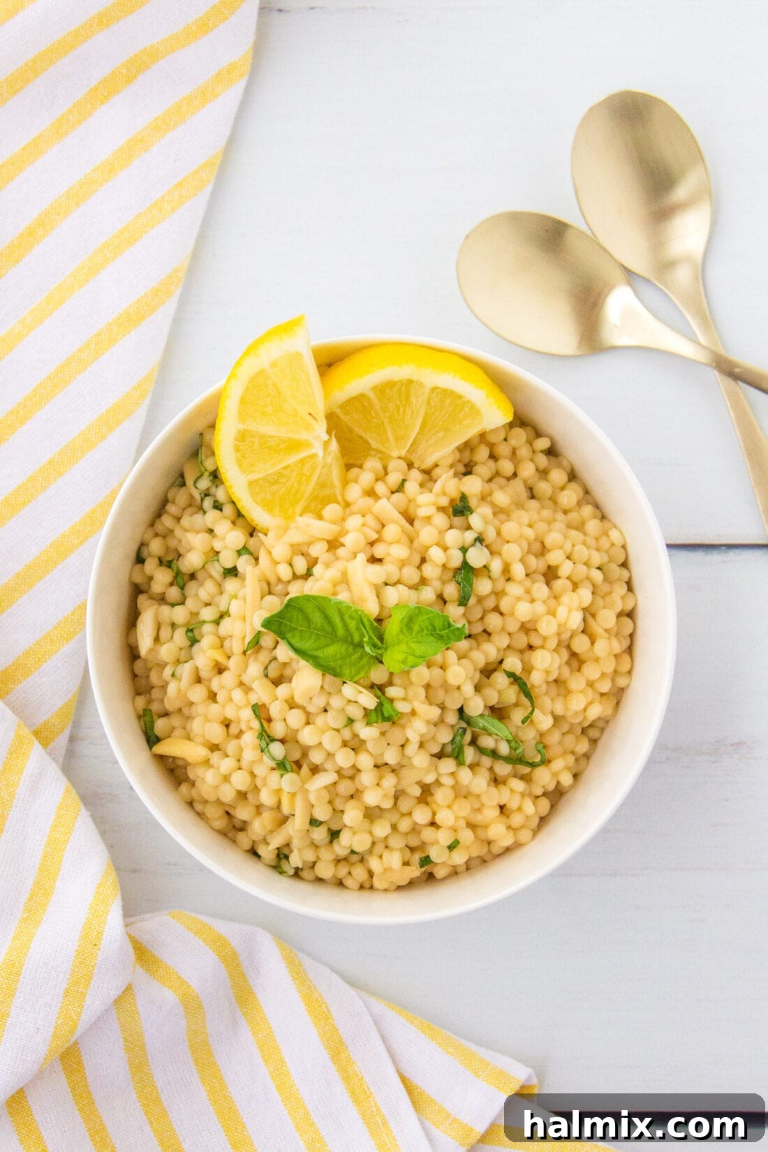 Zesty Lemon Couscous 8 Overhead photo of a white bowl filled with Lemon Couscous, garnished with fresh basil, showcasing its vibrant appeal.