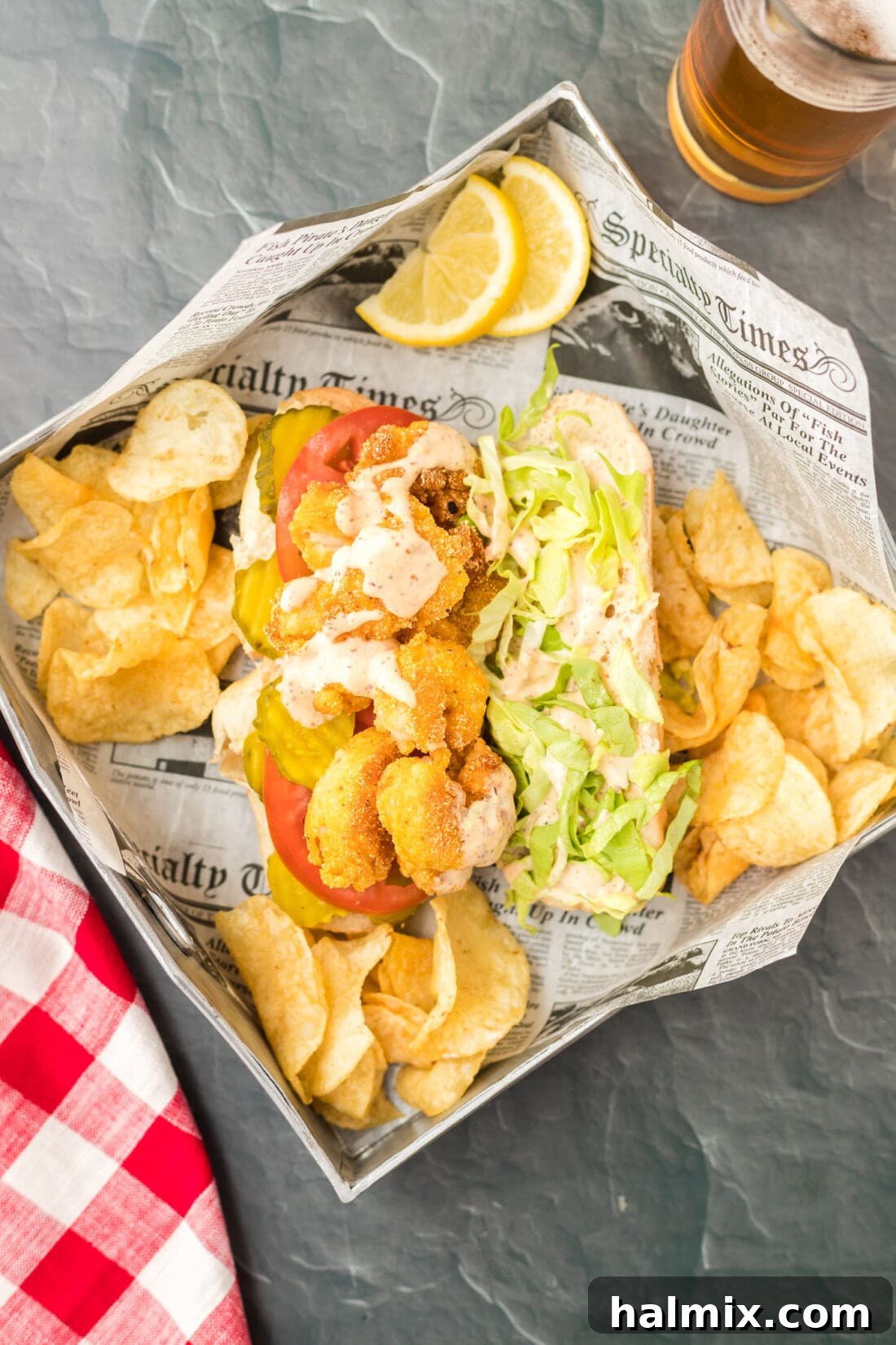 A Shrimp Po Boy sandwich served in a basket with potato chips, ready to be enjoyed.