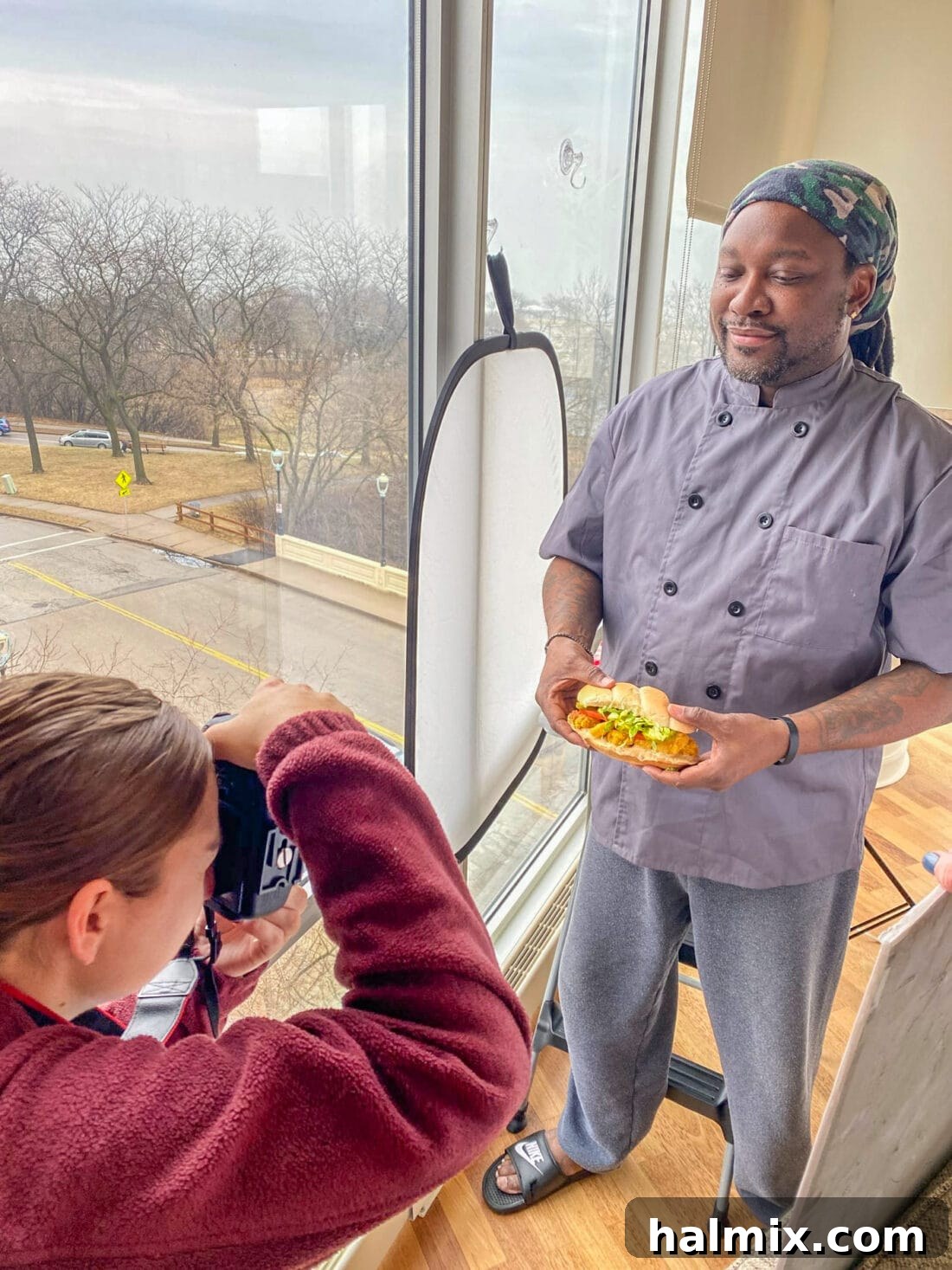 Chef Antoine posing with a freshly made shrimp po boy sandwich for a photoshoot.