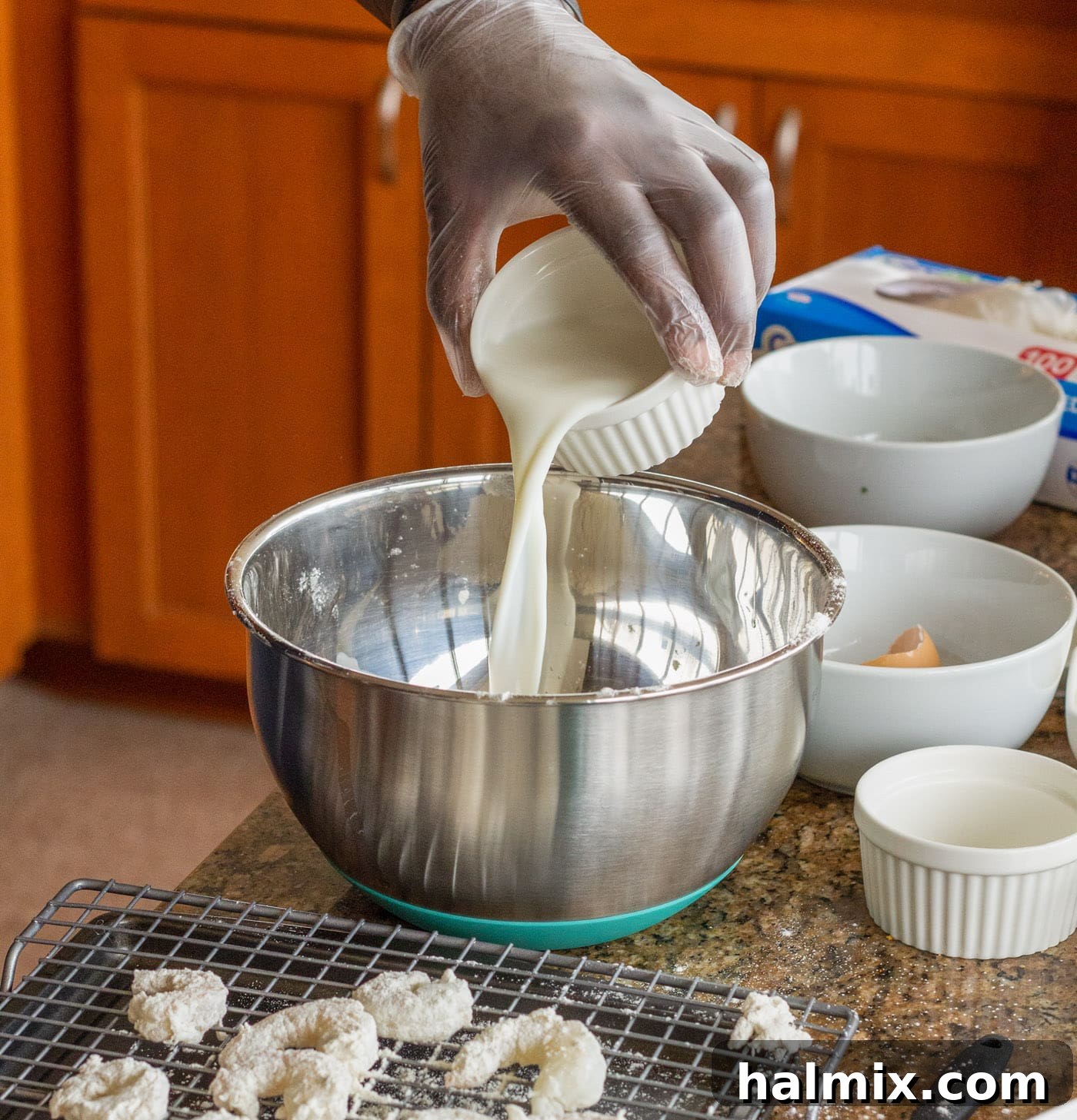 Pouring milk into the egg and flour mixture to create the wet batter for shrimp.