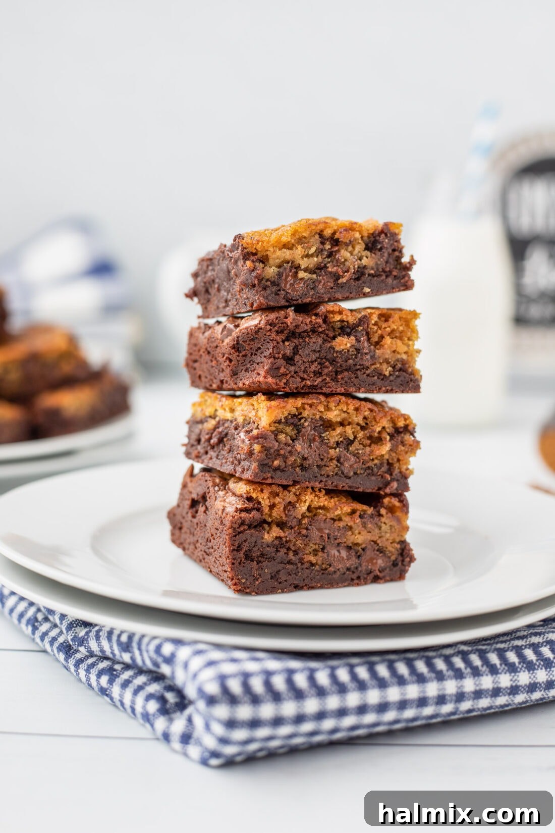 Stack of freshly baked Brookies on a white plate, showcasing their distinct cookie and brownie layers